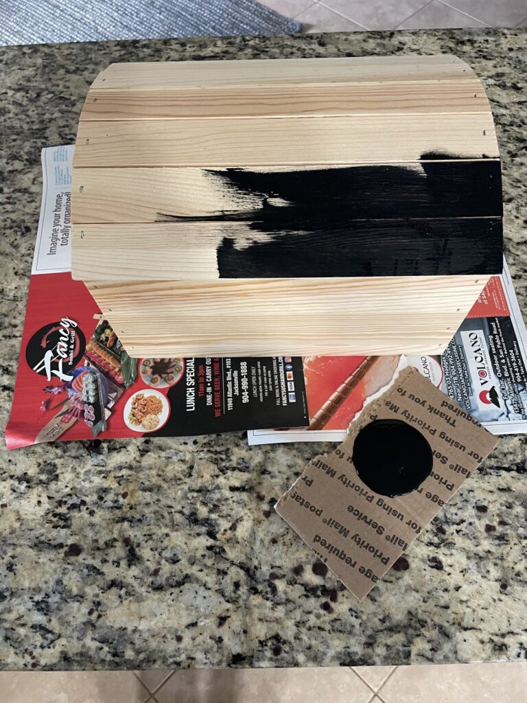 Adding black paint to the craft box to help make it look like a pirate treasure chest.