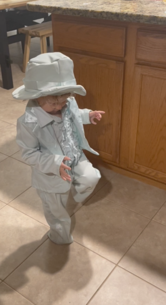 Young kid dancing in an blue suit in the kitchen