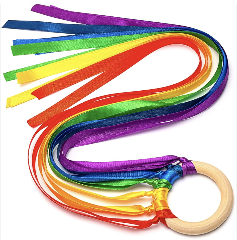 Thin rainbow colored ribbons attached to a wooden craft circle for babies and kids to play with