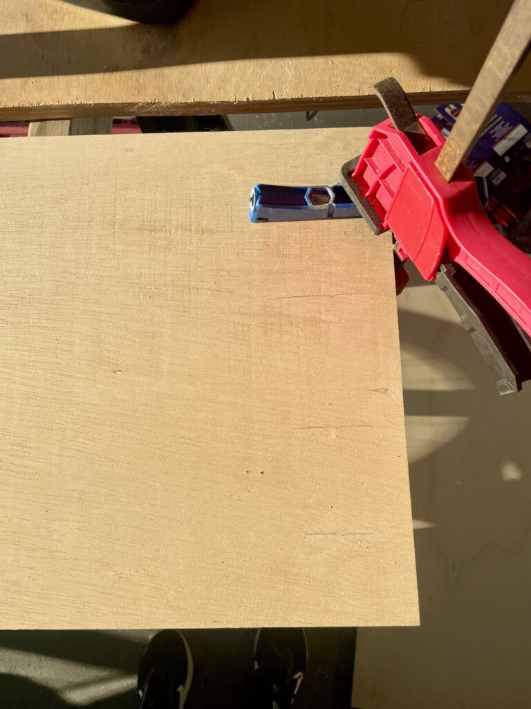 Pocket Holes on the cabinet piece of plywood with pencil marks and single pocket hole jig